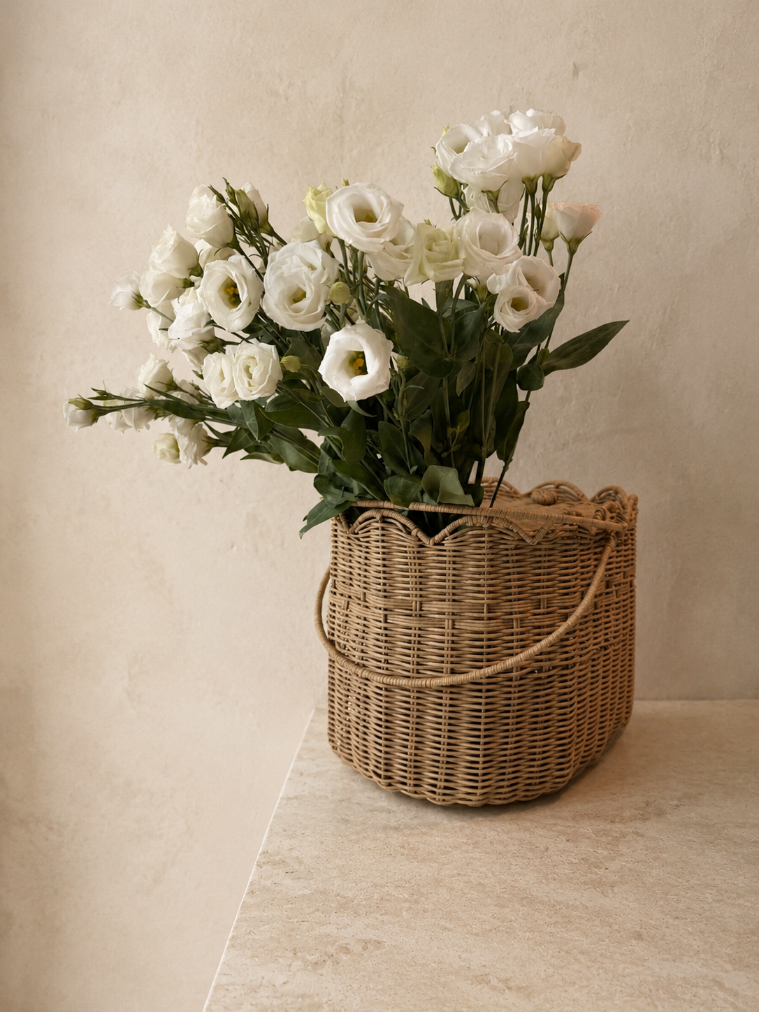 White lisianthus gathered in a woven flower basket