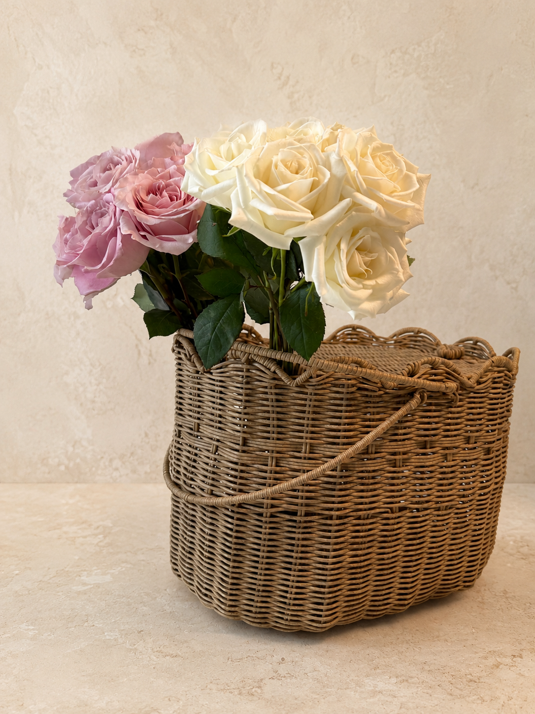 Blush and ivory roses gathered in a woven flower basket